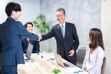 笑顔で握手をするビジネスパーソン