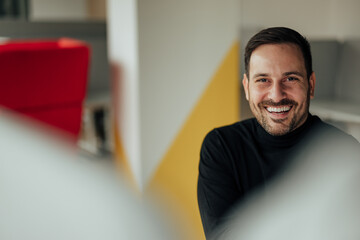 Obraz premium Portrait of cheerful caucasian office worker, happily working in the morning.