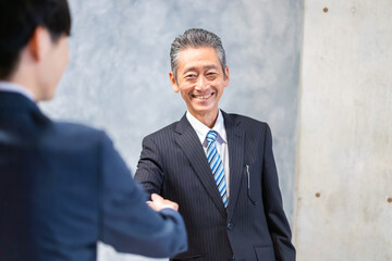 笑顔で握手をするビジネスパーソン
