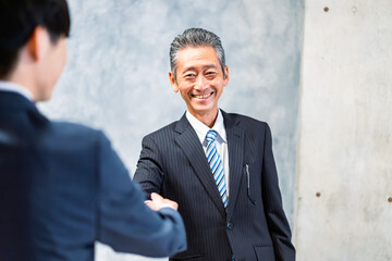 笑顔で握手をするビジネスパーソン