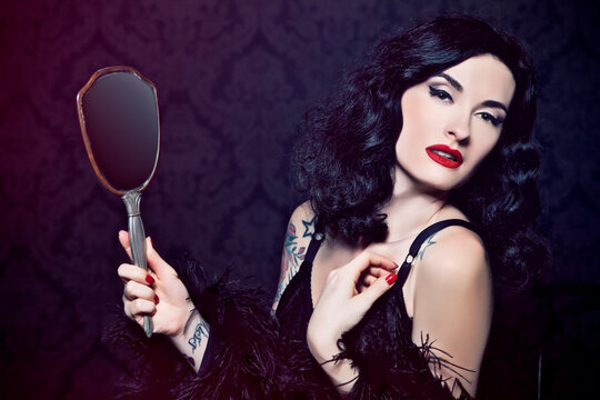 Retro Burlesque Diva With Tattoes Holding A Mirror