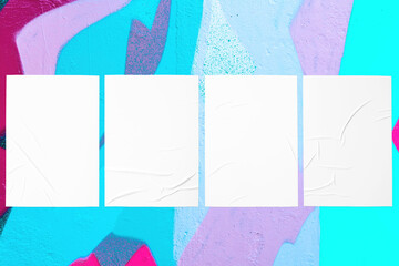 Closeup of colorful messy painted urban wall texture with four wrinkled glued poster templates....