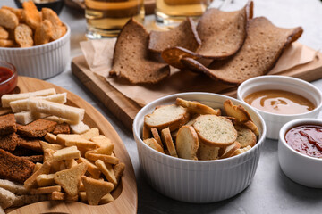 Different crispy rusks with dip sauces on light table