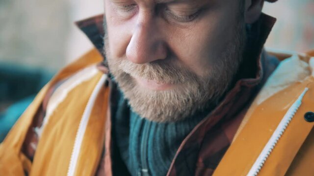 A tramp is trying to warm his hands up in a close up