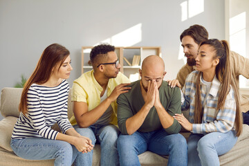 Supporting group of people comfort their sad male friend who shares his problems with friends....