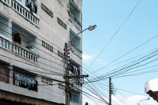 Electrical Cables In The Foreground Of Apartments, Electrical Wire, Get Tangled On The Power Pole Not Neat Bangkok, Thailand