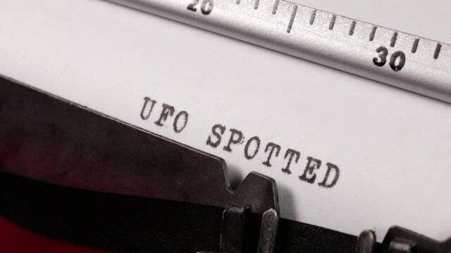 Typing A Report Of The Sighting Of A UFO An Unidentified Flying Object On An Old Manual Typewriter. An Alien Spacecraft Spotted.