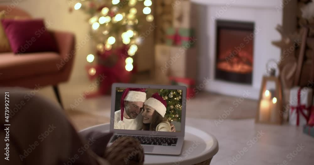 Canvas Prints Happy young couple using laptop for greeting their friends or family via video chat on Christmas eve