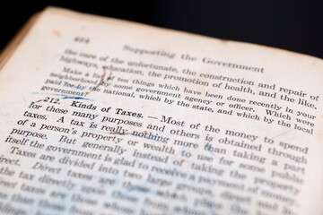 Vintage Book Page About Taxes on a Black Background