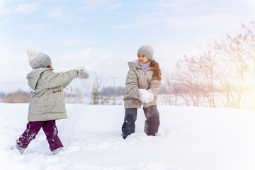 Happy children play snowballs, run, throw snow. Funny kids play games indoors in the winter with snow