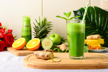 detox green juice, glass with green juice on a wooden board, small fruit ingredient for the juice next to the glass with the drink - Powered by Adobe