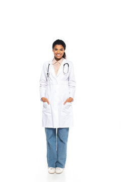Full length of smiling african american doctor with stethoscope looking at camera on white background.