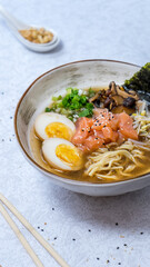Ramen with salmon, green onions, soy sprouts, noodles, mushrooms in broth on a white background, general plan