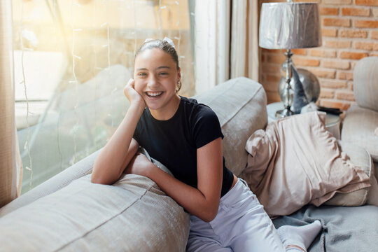 Happy Girl Sitting On Sofa At Home