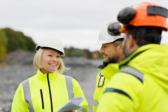 Engineers in reflective clothing discussing plans