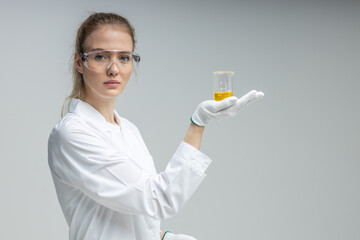 Chemical test tubes and flasks with petroleum products, the girl is a laboratory assistant, safety glasses