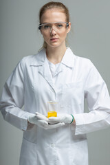 Chemical test tubes and flasks with petroleum products, the girl is a laboratory assistant, safety glasses