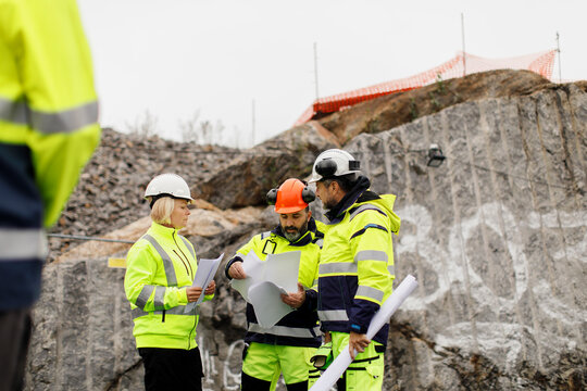 Engineers in reflective clothing discussing plans