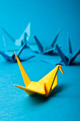 origami bird yellow among blue ones, uniqueness concept