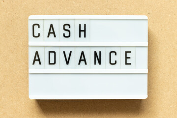 Lightbox with word cash advance on wood background