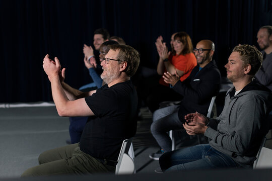 Smiling TV show audience clapping