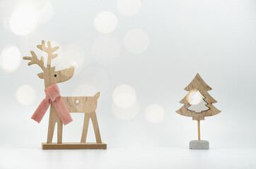 Christmas card with wooden figures of a deer and a fir tree. Minimalism, bokeh, light colors, eco-friendly materials. High quality photo.
