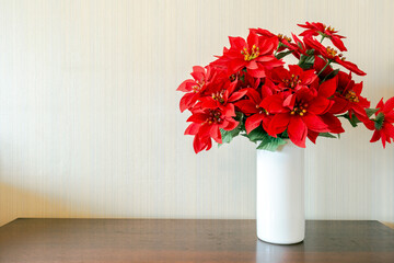 Christmas flower red poinsettia on wooden table with copy space, Merry Christmas decoration at home