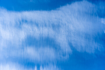 White cloud stripes over the blue sky background