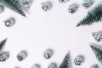 Christmas frame with fir-trees and disco balls on white background, greeting card with copy space