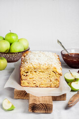 Apple and coconut loaf cake on wooden cutting board