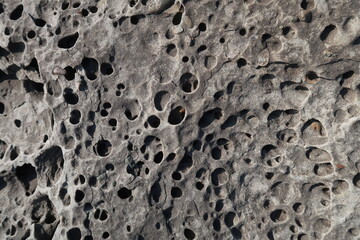 texture of porous stones on the beach, nature, natural phenomena, brown-gray stones