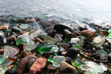 colourful shards of glass polished by sea on a smooth stone, small glass pieces  
