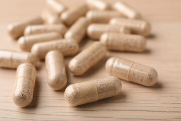 Gelatin capsules on wooden table, closeup view