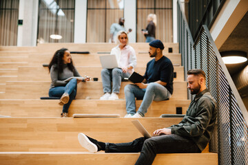 People relaxing on stairs in office building