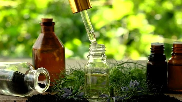Black cumin oil in a bottle. Selective focus.