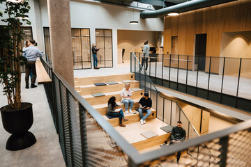 People relaxing on stairs in office building