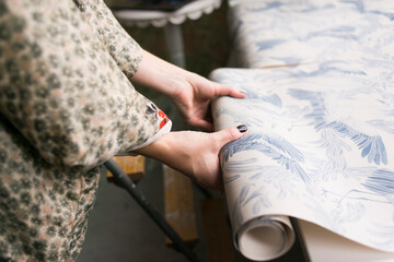 Woman's hands holding wallpaper