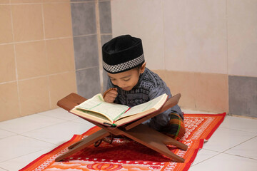 Handsome Asian boys are praying and studying al-qur'an