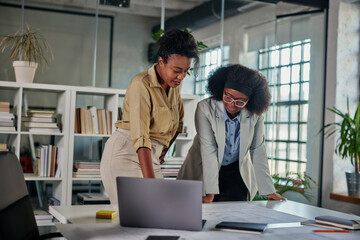 Two african american businesswomen having a discussion in an office