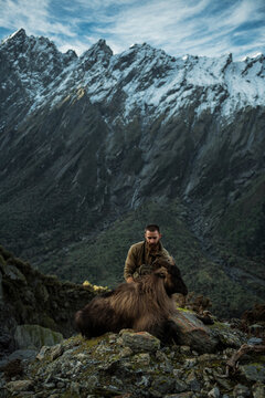 Hunter sitting near dead mountain goat