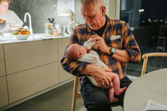 Grandfather feeding grandchild