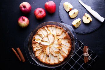 Apple pie in a gold plate on a dark background