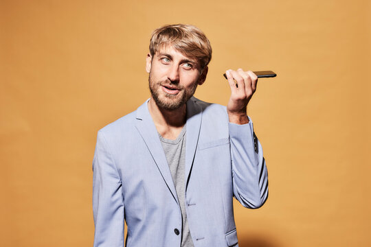 Man in sports jacket listening voice mail through smart phone