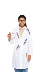 Smiling african american oculist in eyeglasses and coat looking at camera isolated on white.