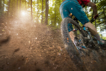 Man drifting bicycle on dirt road in forest