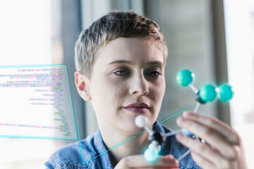 Businesswoman looking at molecular structure at office