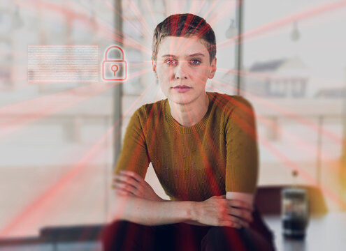 Female Entrepreneur Sitting On Desk With Network Security Icon And Light Beams At Office