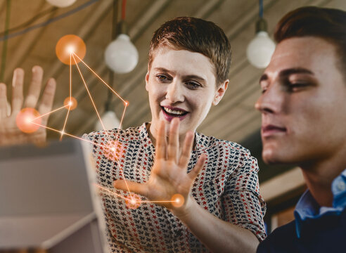 Businesswoman explaining computer networks to male colleague at office