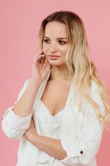 beautiful girl in a white suit on a pink background
