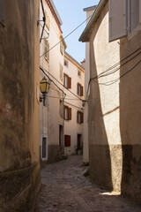 A quiet residential street in the historic medieval centre of Vrbnsk hill village on Krk Island in the Primorje-Gorski Kotar County of western Croatia
